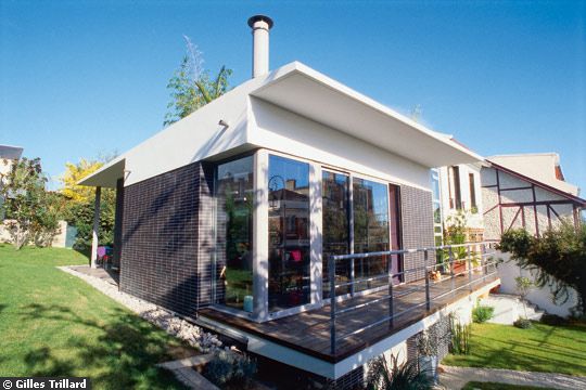 Extension moderne avec toiture terrasse et patio végétalisé